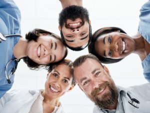 Portrait of a group of medical practitioners joining their heads together in a huddle.